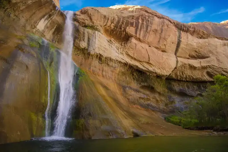 Lower Calf Creek Falls dropping down a streaked sandstone wall