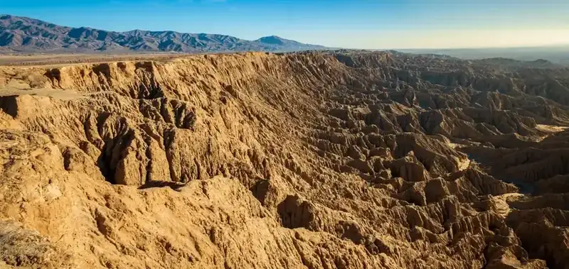 Eroded badlands running to distant mountains above the Anza-Borrego desert floor
