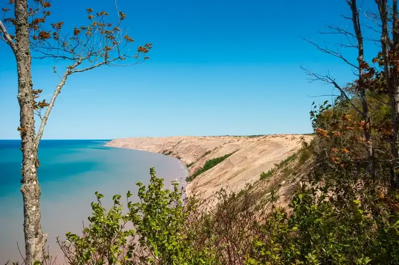 The Grand Sable Dunes running along the Lake Superior shore, framed by trees on the bluff