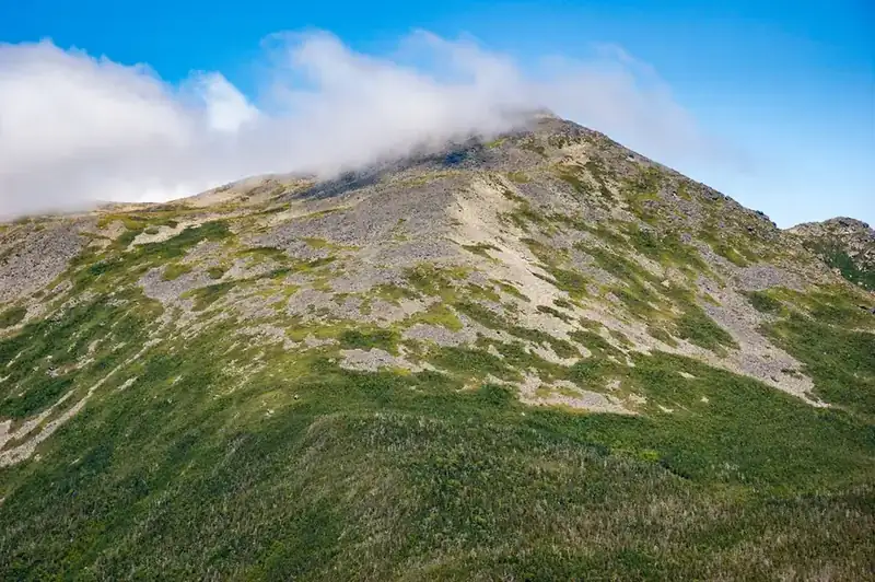 Cloud tearing over a bare alpine summit above the treeline